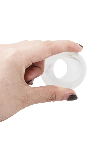 Hand holding clear hollow butt plug to show size and thickness