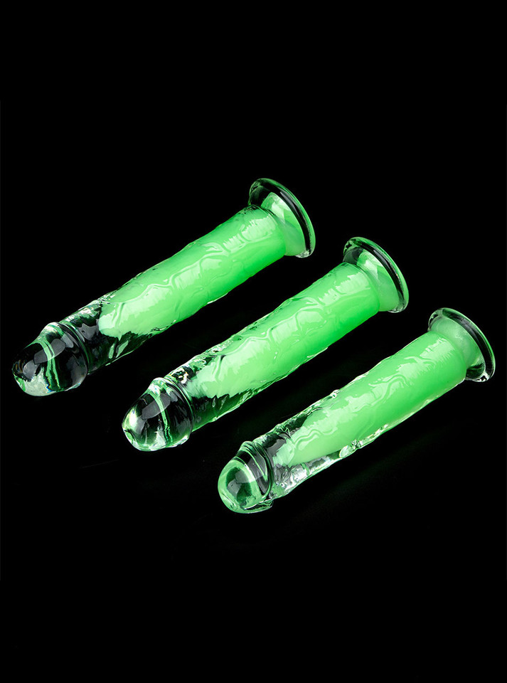 Suction cup glowing dildos laid out flat, showcasing transparent TPE