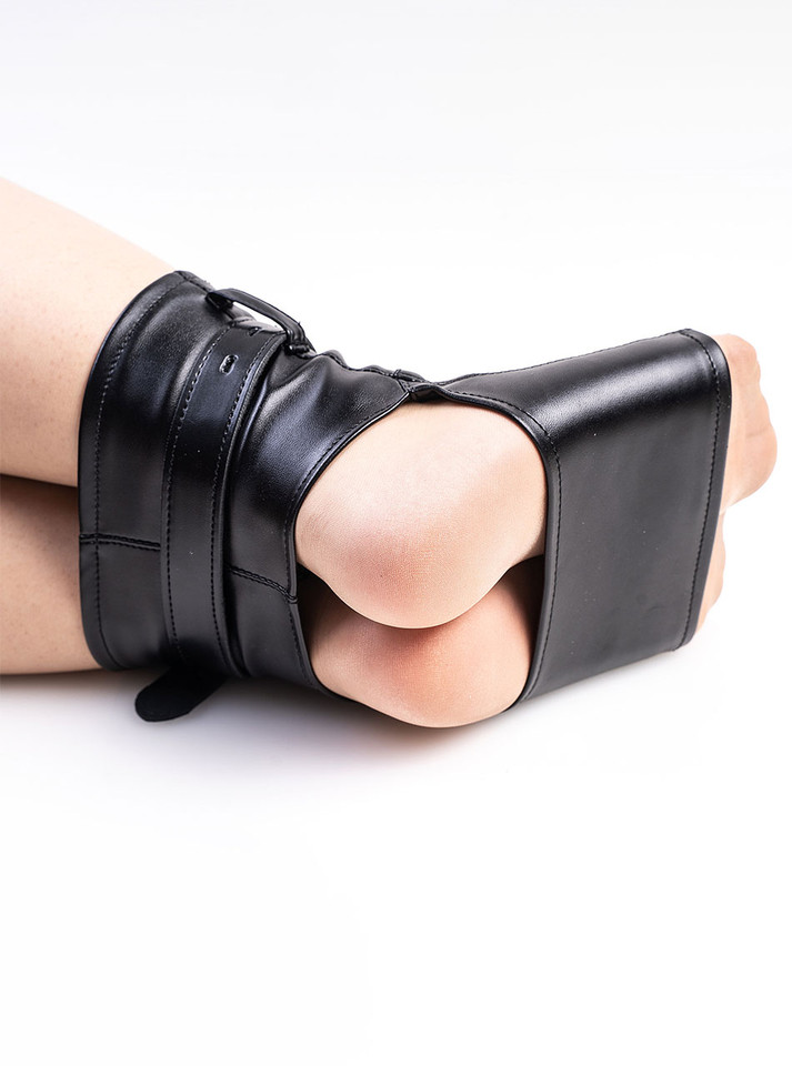 Cuffs on model’s feet, securing them in pointed position