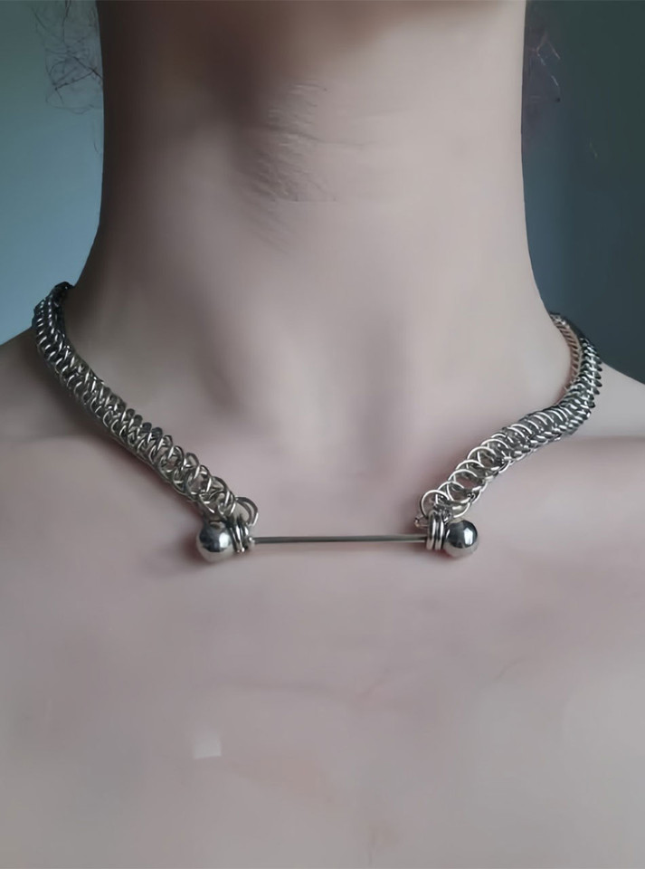 Person wearing bar chain choker with steel shine against skin
