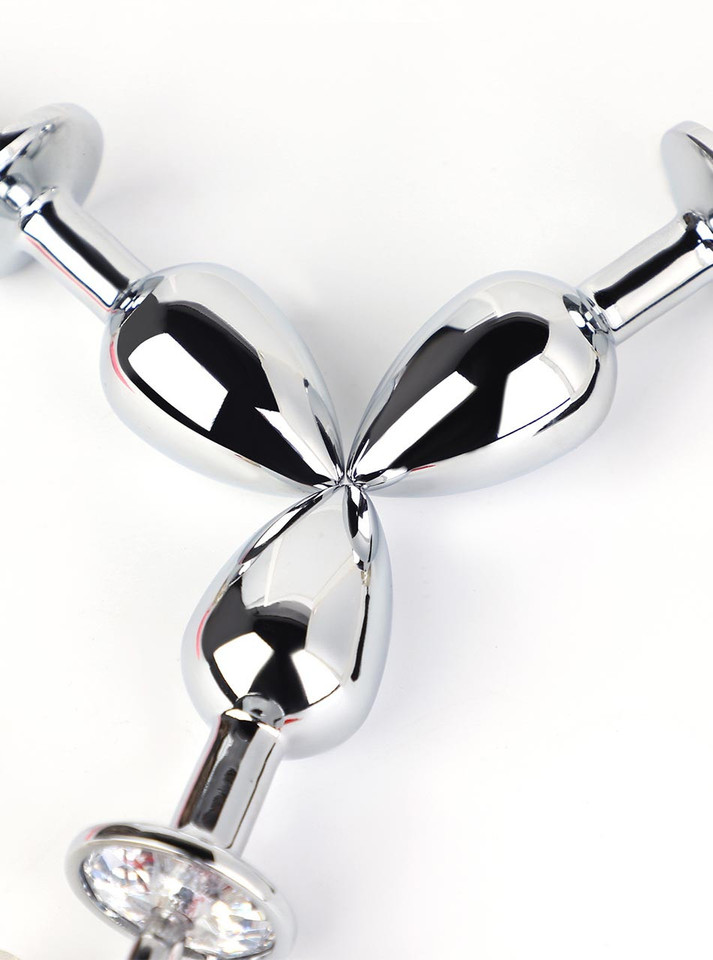 Close-up of smooth silver metal butt plugs with polished teardrop shape
