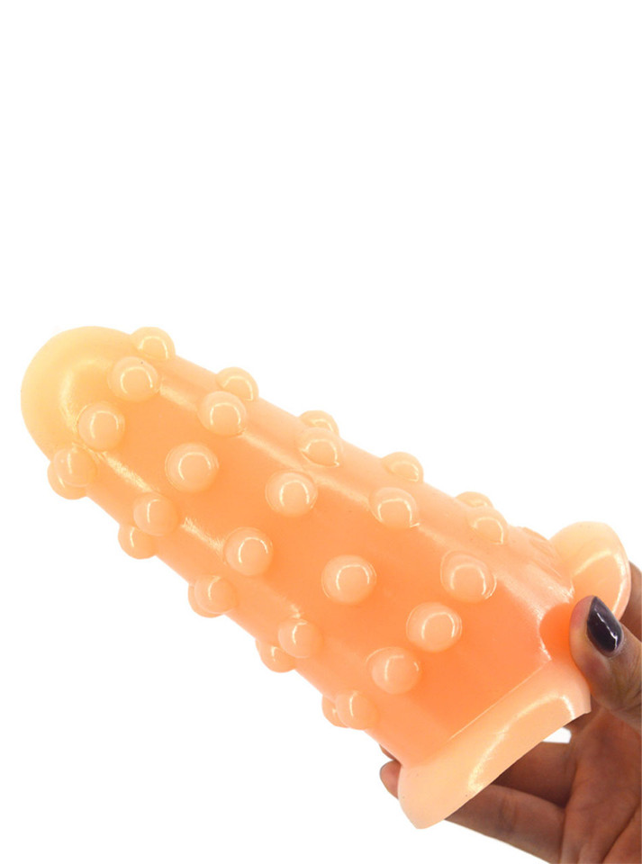 Nude oversized textured PVC butt plug shown at an angle with raised rounded nubs