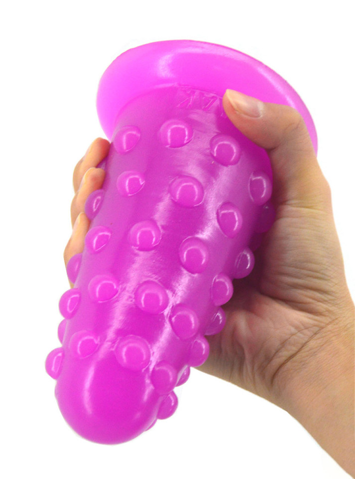 Purple XL nubbed PVC butt plug held upside down to show its wide flared safety base