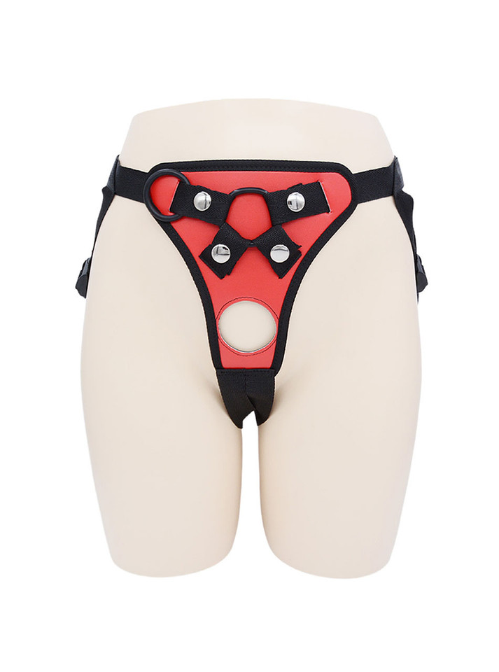 Front view of Red faux leather strap-on harness with round front opening and metal hardware.