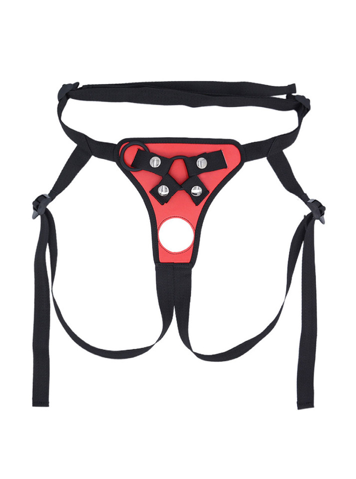 Flat lay of Red faux leather strap-on harness with front opening, strap details and black trim.