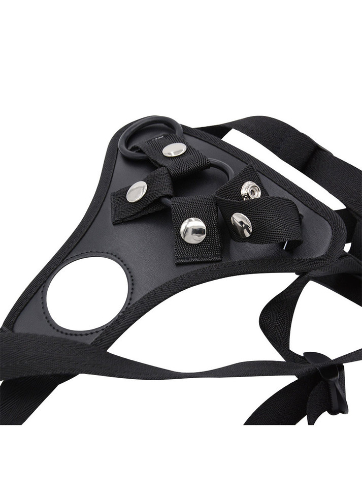 Close-up of black faux leather harness front panel with snap fasteners and ring hardware.
