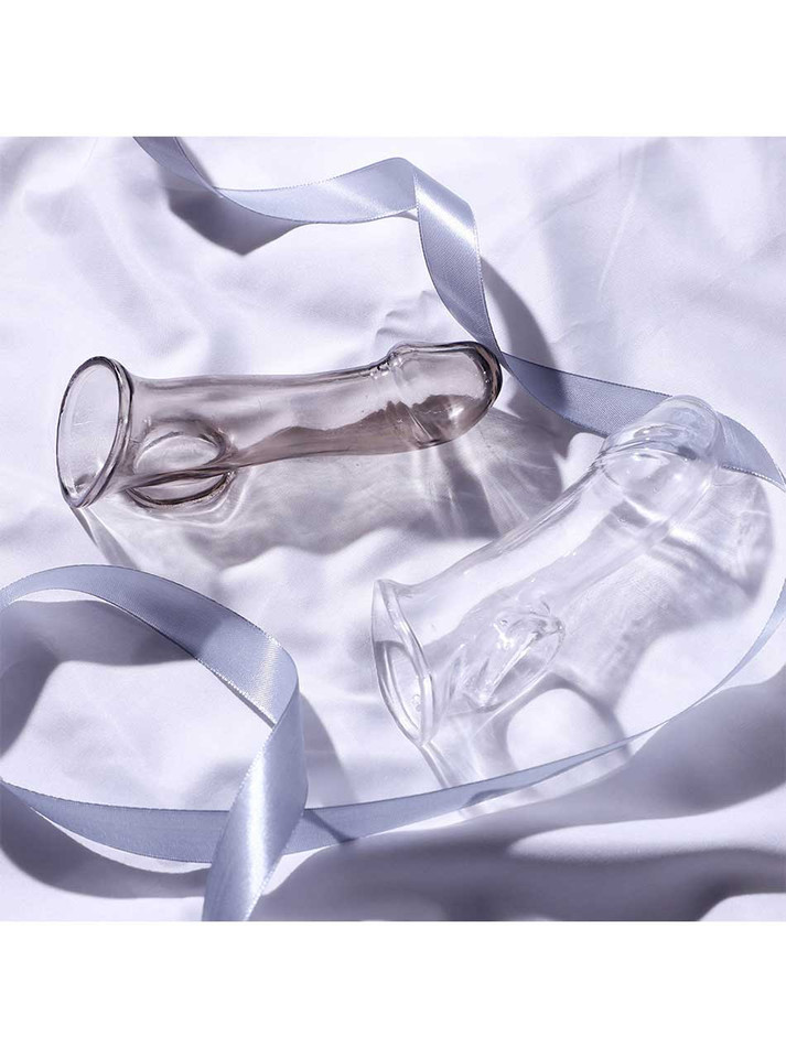Crystal Black and Crystal Clear smooth curved TPE penis sleeves displayed together on satin