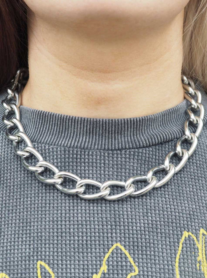Silver chunky oval-link necklace worn around neck