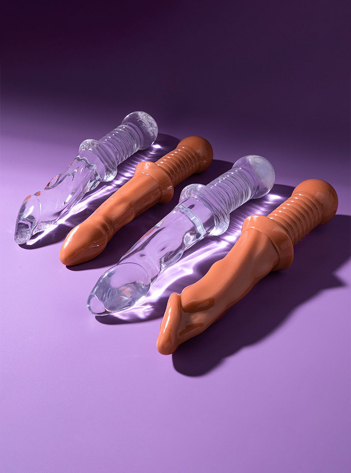 Clear and nude Fantasy Sword Grip Dildos in Small and Large sizes arranged on purple background