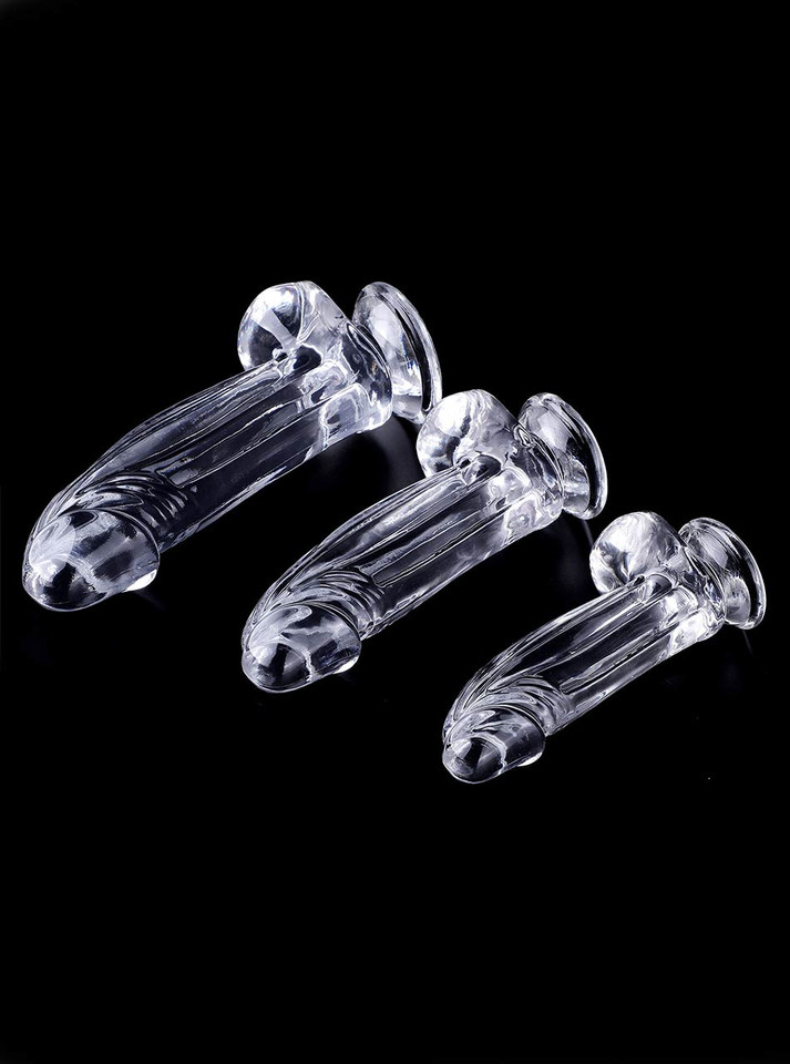 Small, Medium and Large clear realistic dildos with balls and suction cups lying on black background