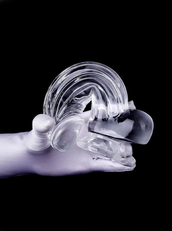 Clear flexible realistic dildo with balls and suction cup bent in hand