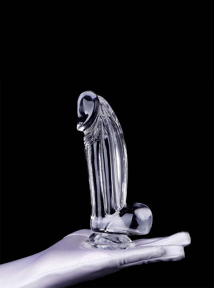 Clear realistic dildo with pronounced head, balls and suction base standing upright