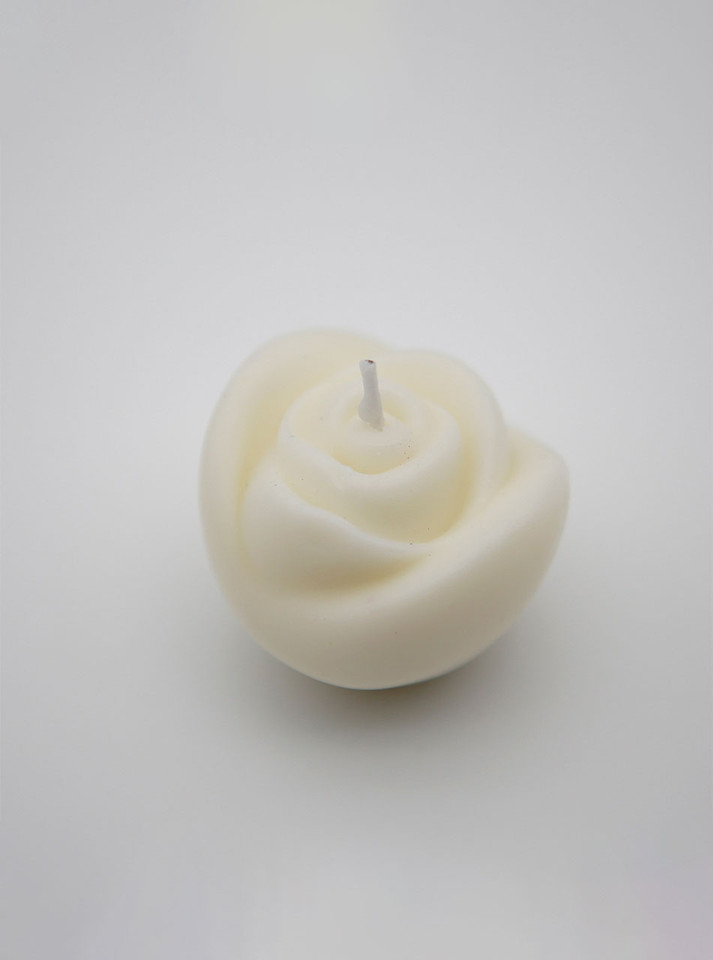 Close-up of the white, rose-patterned candle, symbolizing purity and passion.
