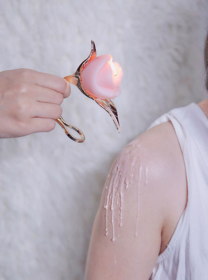 Luxurious gold leaf candle holder with a rose candle, combining classic beauty with sensual warmth.