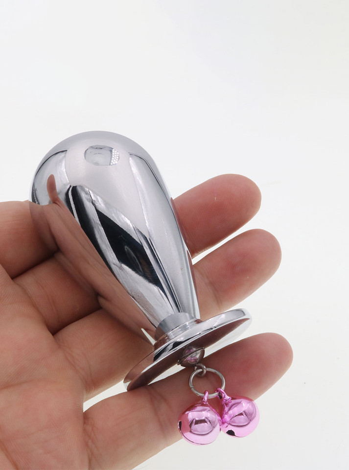 Hand holding a mushroom-shaped aluminum butt plug, showcasing its compact size and attached pink chimes.