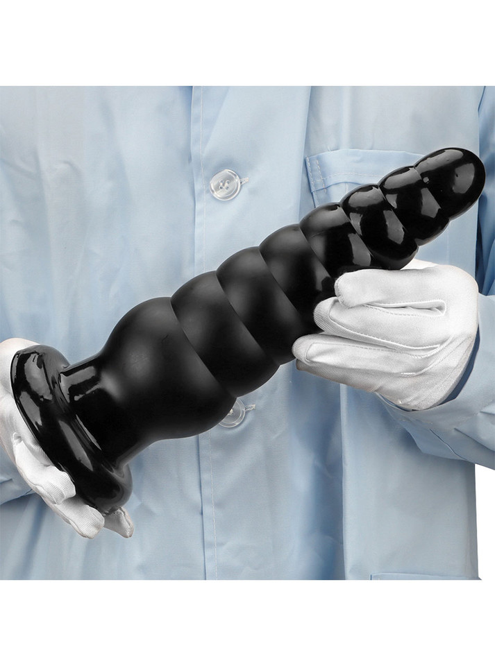 Person holding the ribbed PVC anal plug, showing its massive size.