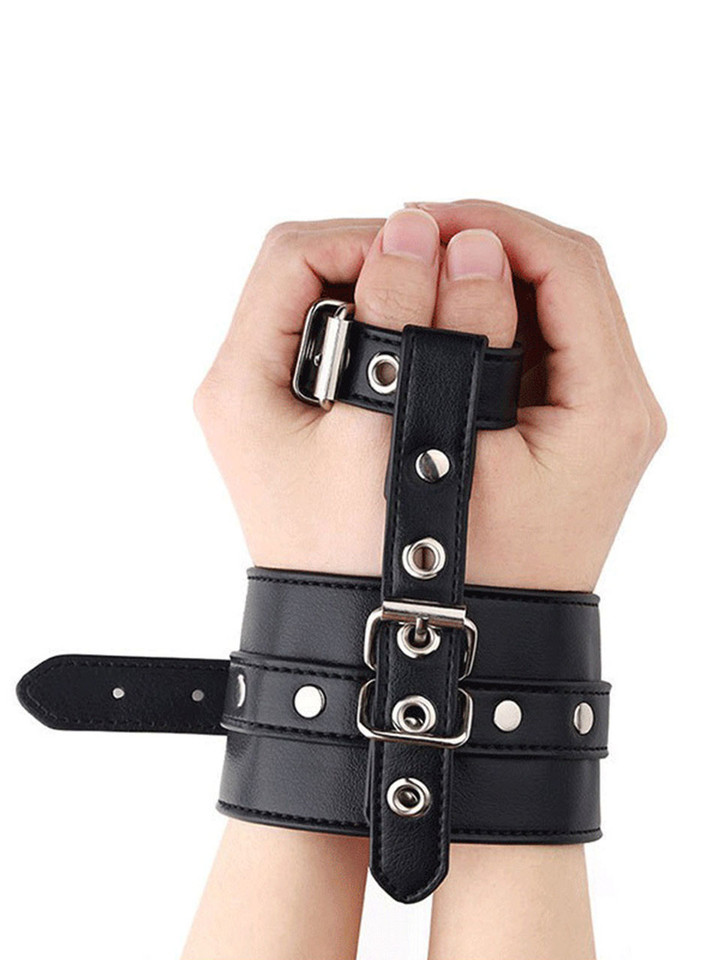 Hands tightly secured in the Forced Wrists Binder, emphasizing the snug double-buckle design.