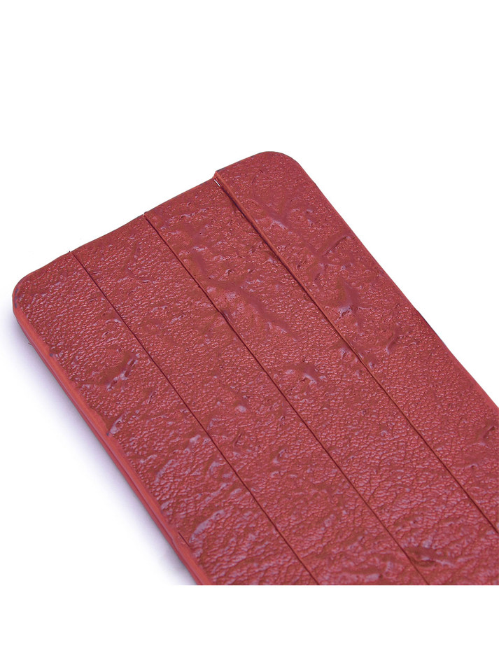 Close-up of the hand-distressed red leather surface highlighting its unique texture.