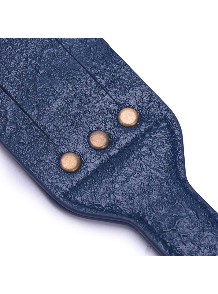 Close-up of the textured navy leather surface with metallic rivet details.
