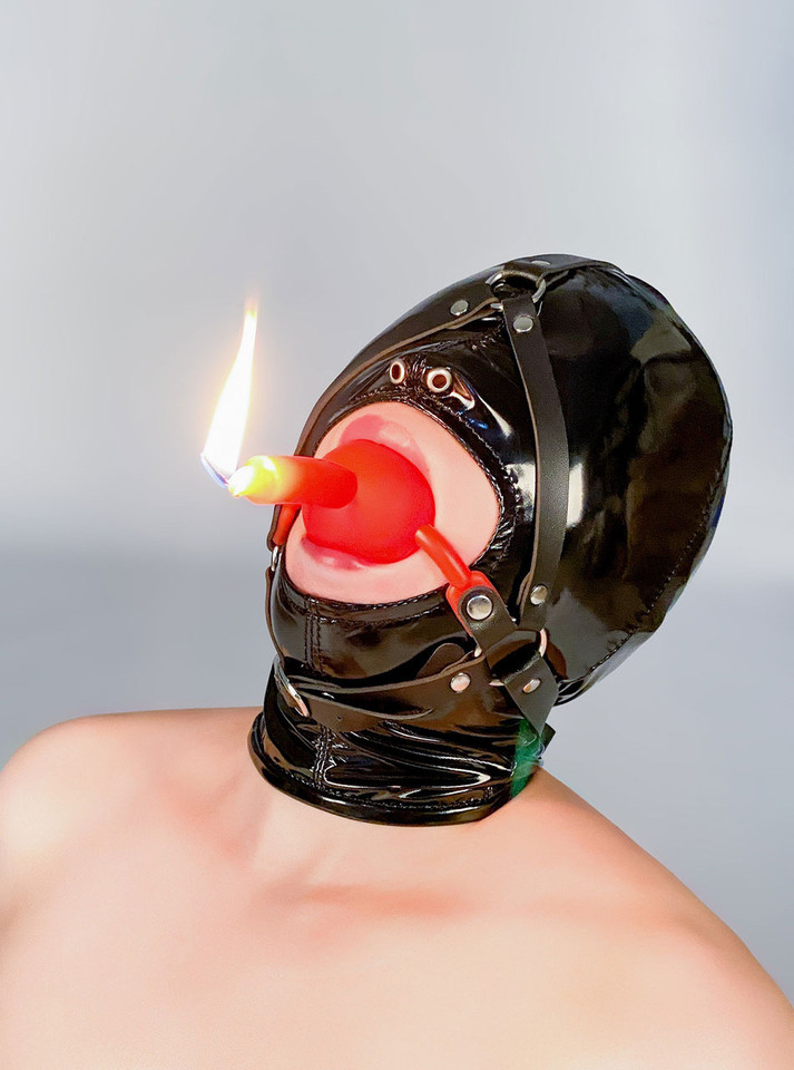 Ball gag with a low-temperature candle inserted, ready for wax play.