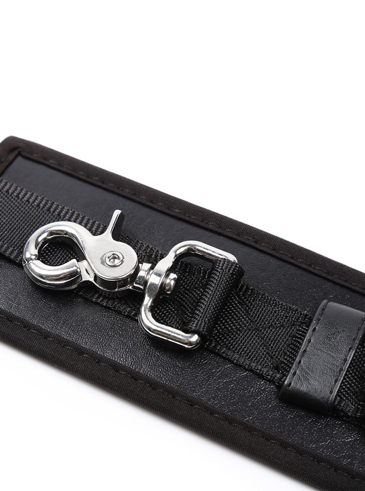 Macro view of the silver swivel clip and D-ring attached to the leather strap