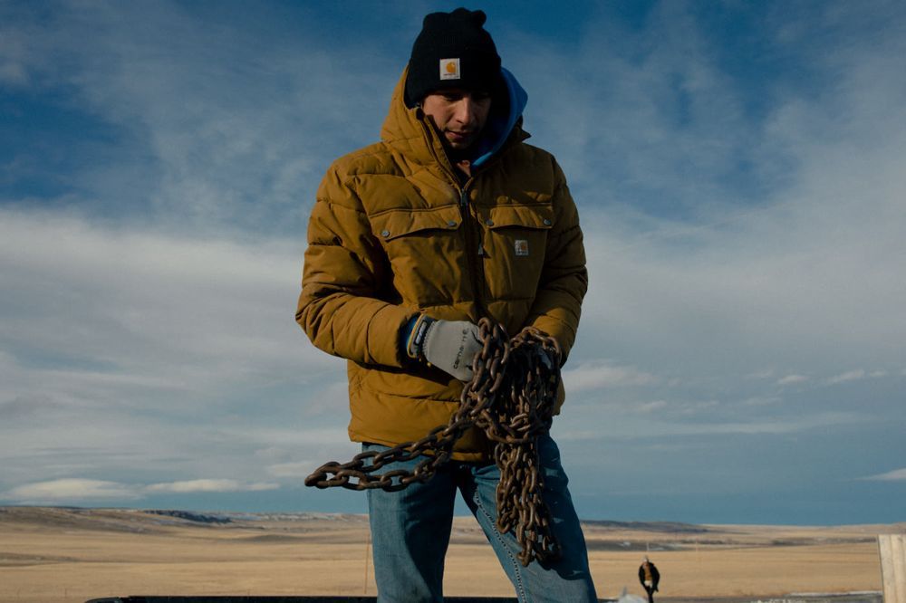 Worker in an insulated jacket carrying chain