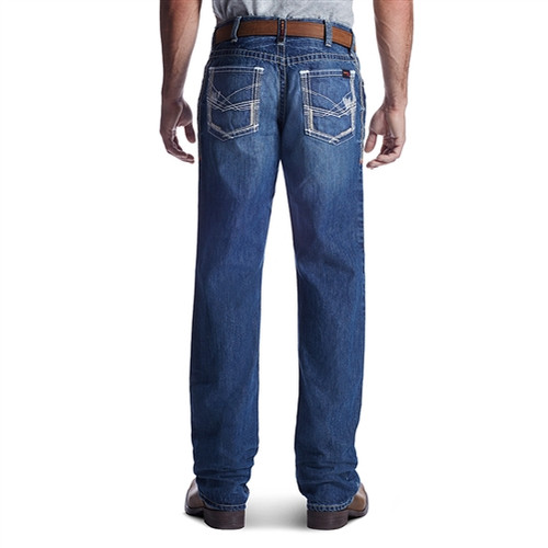 A pair of FR Ariat M4 Ridgeline boot cut flame resistant jeans, made from 13 oz ring-spun cotton denim, featuring a relaxed fit through the waist, hip, and thigh, a low-rise waist, heavy-duty zippers and hardware, anchored belt loops, extra-deep front pockets, and fashion back pockets.