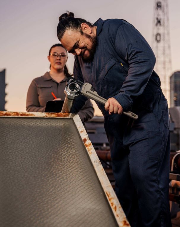 Mechanic in navy coveralls with a wrench