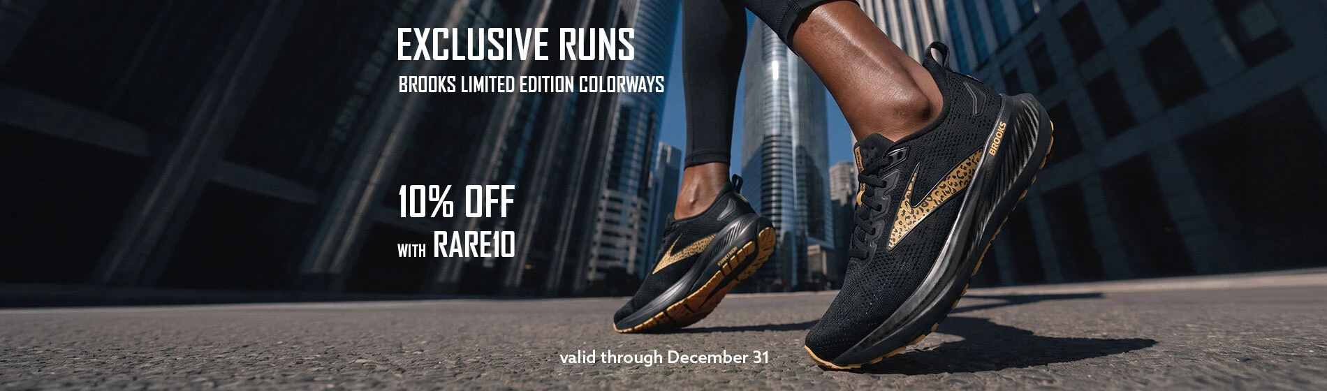 Graphic, close‑up of runner wearing black Brooks shoes with gold and leopard‑patterned limited‑edition design on city street among tall skyscrapers, text, EXCLUSIVE RUNS: Save 10% OFF on BROOKS Limited Edition Colorways — use code RARE10 at checkout - through Dec 31