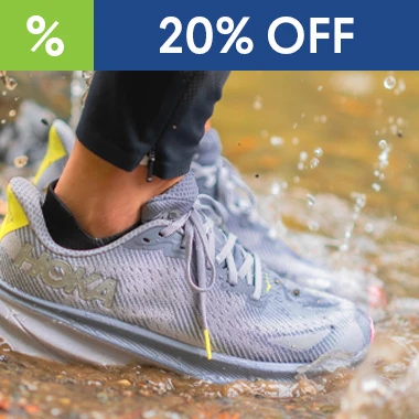 graphic, close-up of a person's feet wearing grey HOKA running shoes splashing through a shallow muddy puddle, text, HOKA Transport GTX & Clifton 9 GTX Sale - now 20% OFF