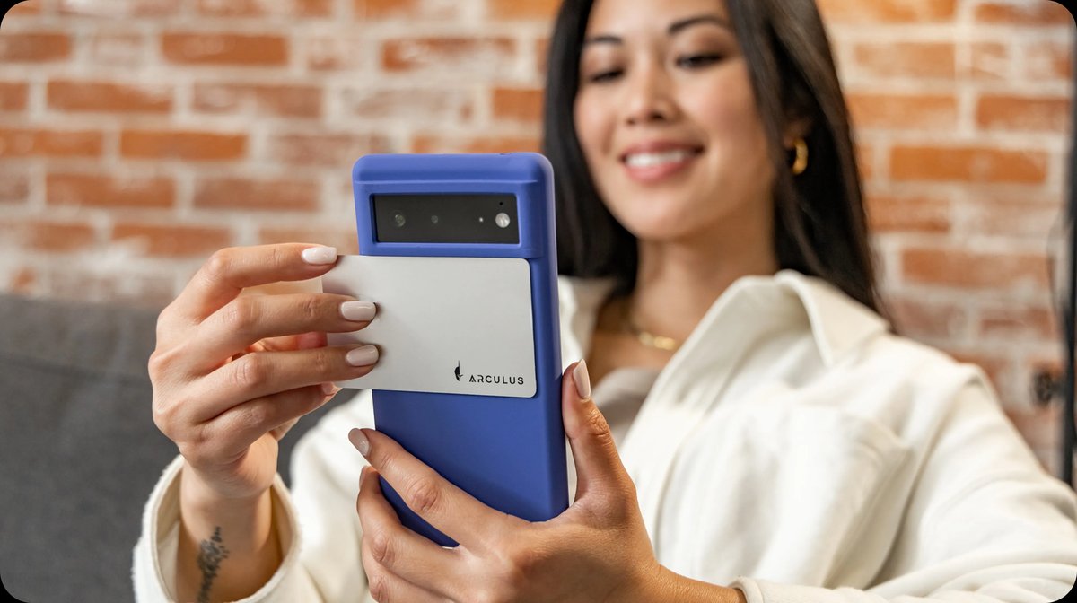 Woman using the Arculus app on her phone with the metal card in hand