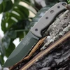 The ESEE-5 (ESEE-5S-KO-OD) shown with its 5.25-inch 1095 saber ground part serrated drop point blade in an OD Green finish, sharpened glass breaker pommel, fire-making bow drill divot, and tan Micarta handle scales. This is a knife-only listing — no sheath is included.