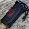 The Izula Gear Arrowhead Wallet (ARROW-WALLET) in black 500 denier Cordura nylon, shown open with its two slide-in carrying trays for ESEE AH-1 arrowheads and a third pocket for cordage or wire.