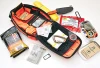 The ESEE Advanced Survival Kit (ESEE-ADVANCED-KIT-OR) shown with its blaze orange Cordura kit bag, detachable map case, and removable backpack straps, alongside the special edition ESEE-4P knife with orange G-10 handle and the kit's survival gear.