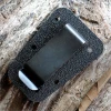 The ESEE Izula Clip Plate (ESEE-IZULA-IZBC) in black, shown with its mounting screws and washers, designed to fit both Izula and Izula-II sheaths.