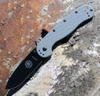 The ESEE Avispa (BRK1301FGB) shown with its 3.50-inch AUS-8 drop point blade in a black finish and flat grind, Foliage Green polymer handle with steel frame lock, and pocket clip for tip-up or tip-down carry.