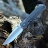 The Chris Reeve Large Sebenza 31 (L31-1652) shown with its 3.61-inch CPM MagnaCut hollow-ground drop point blade in a stonewashed finish, glass-blasted 6AL4V titanium handle with Black Canvas Micarta inlays, and its tip-up titanium pocket clip. The Reeve Integral Lock with ceramic ball interface is visible along the handle.