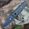 The Benchmade Mini Bushcrafter 165BK is shown, featuring a 3.38-inch Black Cerakote CPM-CruWear drop point full-tang blade, Black Carbon Fiber handle scales, stainless steel hardware, and an included Black Modular Molded Sheath with push-button release.