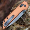 Detailed close-up of the DuraLock crossbar mechanism and thumb studs on the bronze Kershaw Mini Iridium.