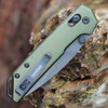 Detailed close-up of the DuraLock crossbar mechanism and thumb studs on the OD green Kershaw Mini Iridium.