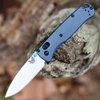 The Benchmade Bugout 535SL-13 is shown open, featuring a 3.24-inch satin-finished CPM-S90V drop point blade extending from a Crushed Silver Crater Blue anodized 6061-T6 aluminum handle with dual thumb studs and AXIS Lock mechanism.