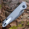 Close-up of the gray-anodized aluminum handle highlighting the titanium pivot trim ring and push button