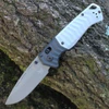 The Benchmade PSK (593GY-02) shown with its 3.45-inch Elmax drop point blade in a satin finish and hollow grind, storm gray Grivory handle scales, and its tip-up reversible pocket clip. The AXIS Assist thumb stud and AXIS Lock bar are visible along the spine of this spring-assisted EDC folder.