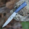 The Benchmade Successor™ (315) shown with its 2.56-inch M390 satin drop point blade, Ash Gray aluminum bolster, and distinct Crater Blue aluminum handle scales. The minimalist nail nick opener is visible along the spine, with the removable pocket clip and black leather sheath shown alongside the knife.