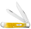 Case Trapper (75310) shown in the closed position against a white background. The handle is yellow Platts jigged cattle bone with a fine, tightly packed jig texture and a nickel silver oval script Case shield inlay at the center. High-polished nickel silver bolsters are visible at both ends. The nail nicks on both the clip point and spey blades are visible at the pivot end. The brass liner frame is partially visible at the handle edges.