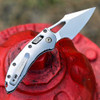 Microtech M-Stitch RAM-LOK Marfione Select 169MRL-10MS4 open back view — 3.05" M390MK stonewash blade, slab-side titanium handle showing RAM-LOK mechanism and bronzed vapor blast hardware