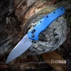 A Kershaw Bareknuckle DuraLock Blue folding knife shown with the blade deployed, highlighting the CPM MagnaCut modified sheepsfoot blade's stonewash finish alongside the Blue anodized aluminum handle and reversible deep-carry pocket clip.