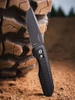 A Pro-Tech Synapse 2 button-lock automatic knife, a collaboration with VERO Design, shown with the blade deployed, highlighting the MagnaMax DLC black spear point blade alongside the black herringbone-textured aluminum handle and machined titanium clip.