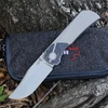 The Boker Plus Collection 2026 (01BP2026) is shown open against a neutral background. The clip point blade carries a stonewash finish and is opened via dual thumb studs, set into a dark gray titanium frame lock handle with FatCarbon Marble Carbon inlays, a textured backspacer with a lanyard hole, and a titanium pocket clip mounted for tip-up carry.