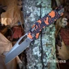 The Microtech MSI RAM-LOK in Orange Leaves, open, showing its Bronzed Apocalyptic Böhler M390MK sheepsfoot blade with a thumb hole, orange-and-black leaf-pattern polymer handle with Tri-Grip texturing, bronze-toned hardware, RAM-LOK crossbar lock, and deep-carry pocket clip.